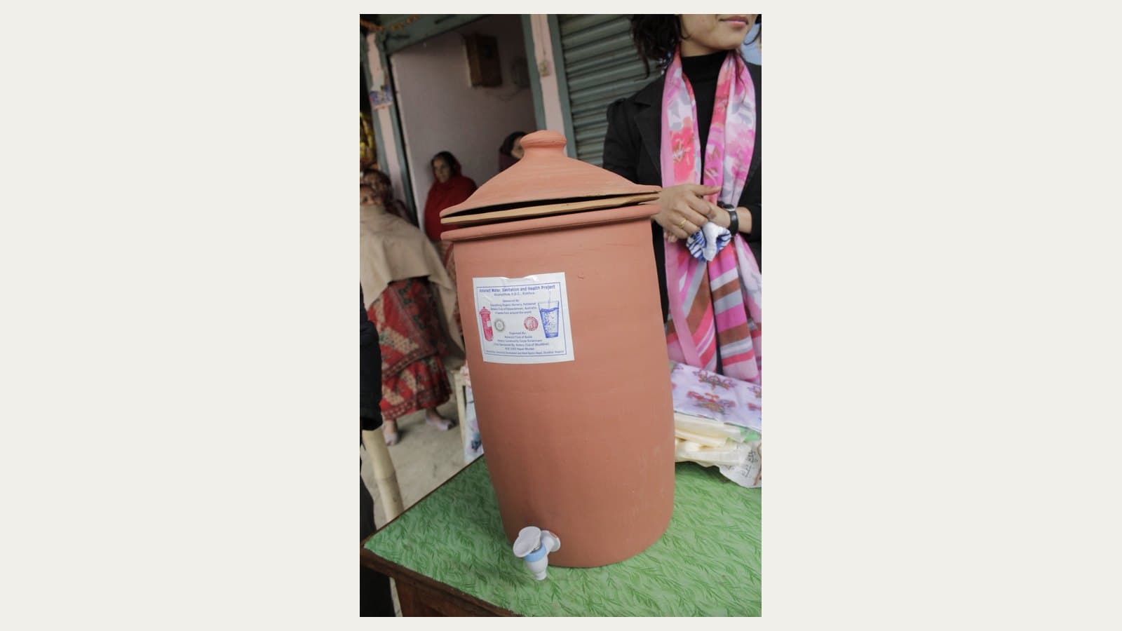 A ceramic household gravity-water-filter unit with its collection vessel and tap.