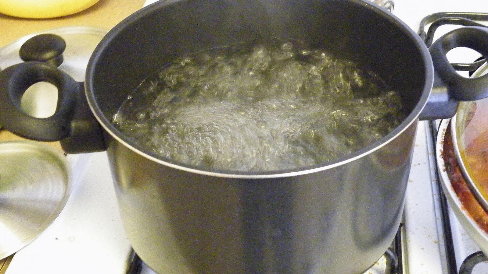 Water boiling in a metal pot on a stove.